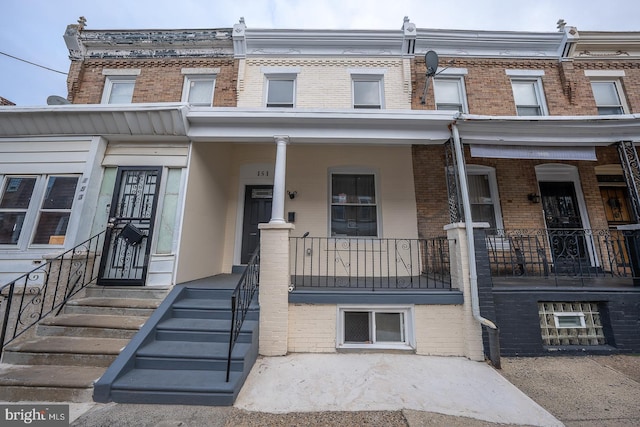 townhome / multi-family property featuring covered porch