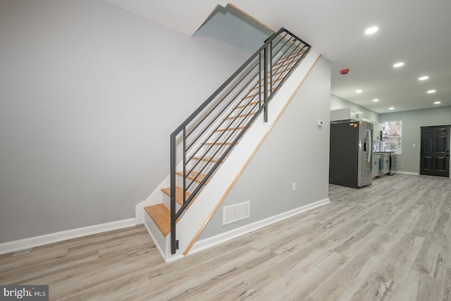 staircase with hardwood / wood-style flooring