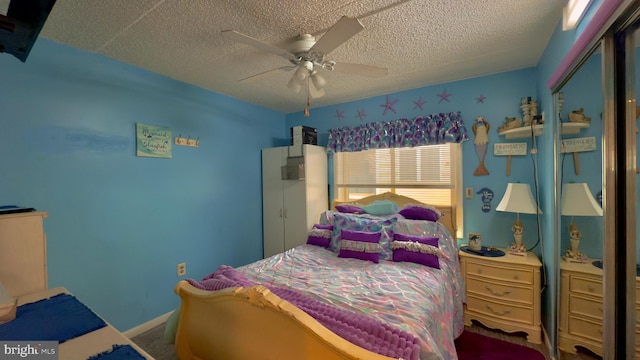 bedroom featuring ceiling fan, a textured ceiling, and a closet