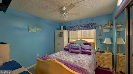 bedroom with ceiling fan and a textured ceiling