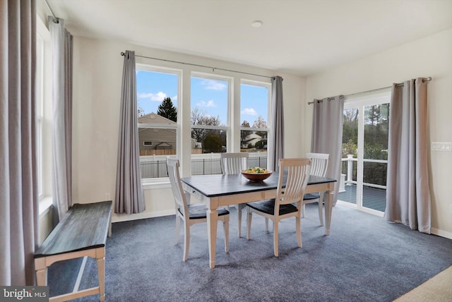 dining space with dark carpet and a wealth of natural light