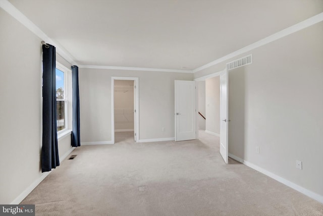 empty room featuring light colored carpet and ornamental molding