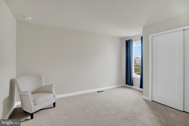 sitting room featuring light carpet