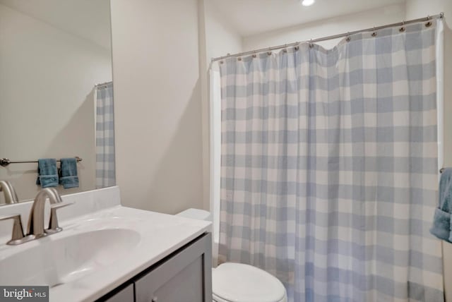 bathroom featuring vanity, toilet, and walk in shower