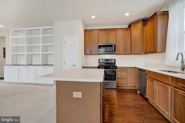 kitchen with hardwood / wood-style flooring, a center island, sink, and appliances with stainless steel finishes