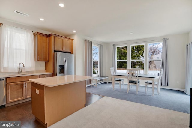 kitchen featuring a center island, stainless steel appliances, dark wood-type flooring, and sink