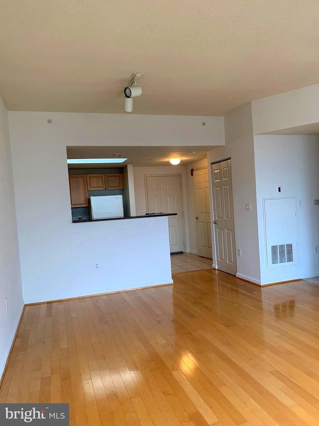 unfurnished living room with light hardwood / wood-style flooring