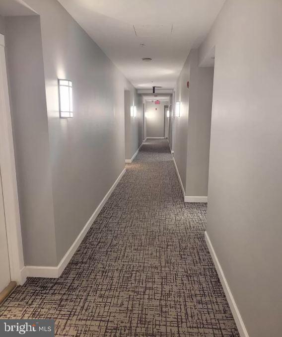 corridor featuring dark carpet