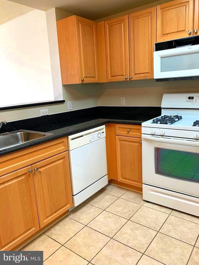 kitchen featuring sink, light tile patterned floors, and white appliances