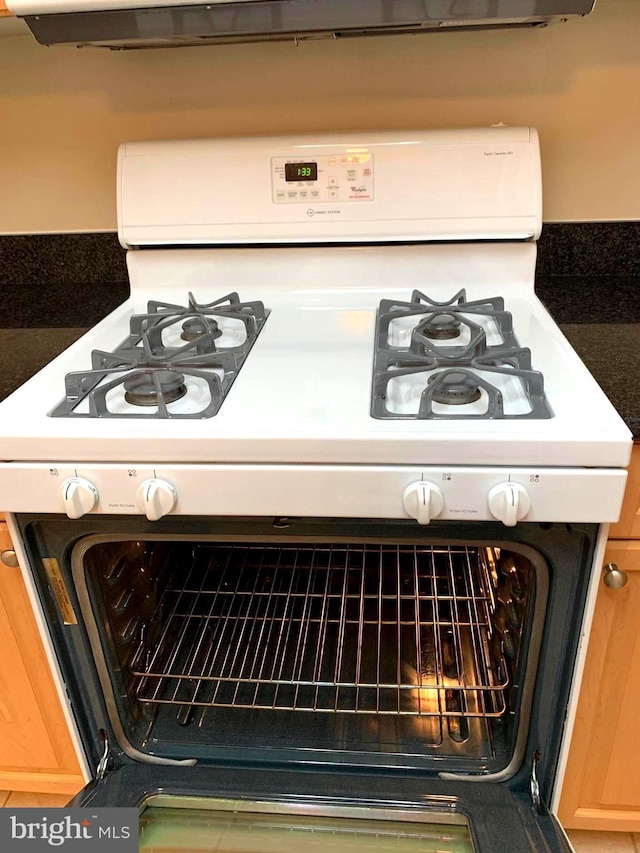 details with gas range gas stove and light brown cabinets