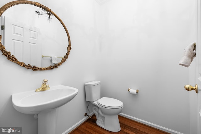 bathroom featuring wood-type flooring and toilet