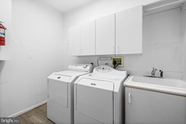 clothes washing area featuring dark hardwood / wood-style floors, cabinets, and separate washer and dryer