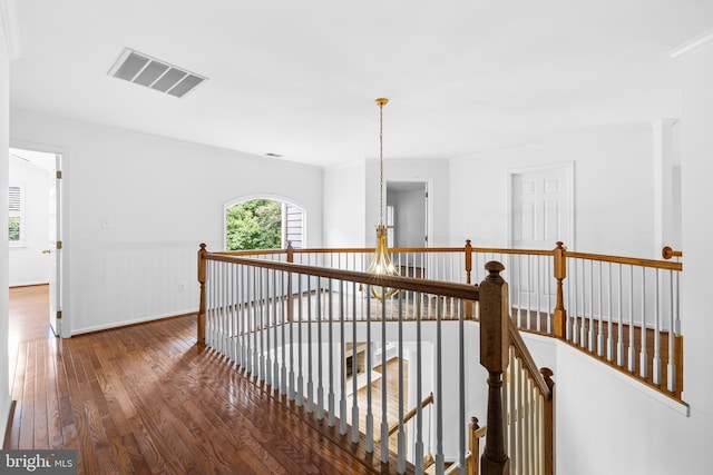 hall featuring ornamental molding, dark hardwood / wood-style flooring, and a notable chandelier