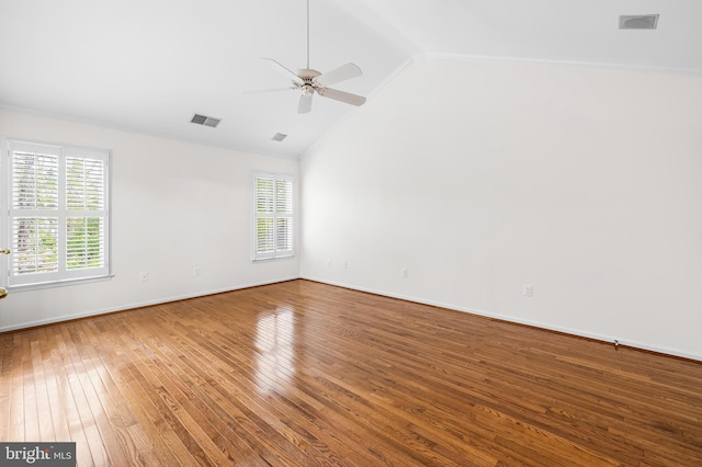 spare room with hardwood / wood-style flooring, vaulted ceiling, a wealth of natural light, and ceiling fan