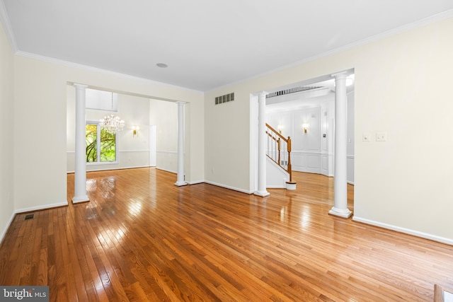 empty room featuring wood-type flooring, an inviting chandelier, and crown molding