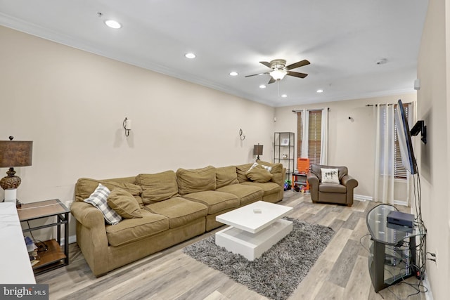 living room with light hardwood / wood-style floors, ceiling fan, and crown molding