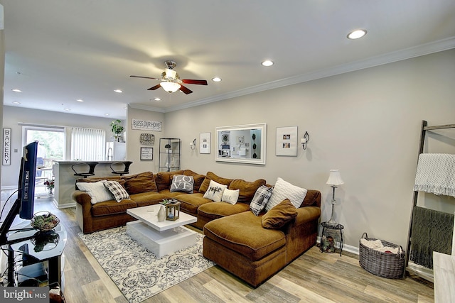 living room featuring ceiling fan, light hardwood / wood-style flooring, and ornamental molding