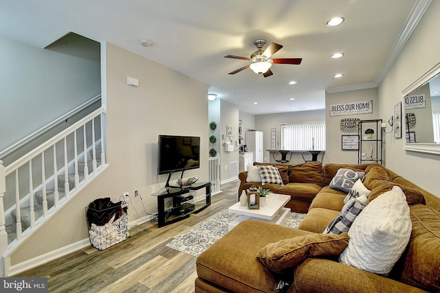 living room with hardwood / wood-style floors, ceiling fan, and crown molding