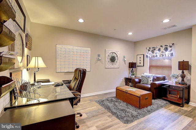 home office with light hardwood / wood-style floors