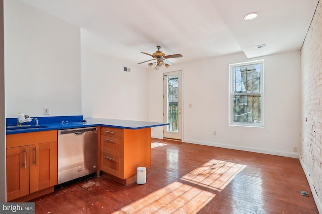 kitchen featuring a wealth of natural light, dishwasher, sink, dark hardwood / wood-style flooring, and kitchen peninsula