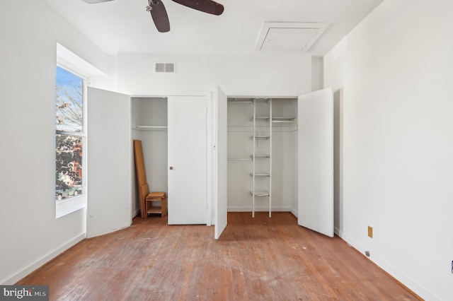 unfurnished bedroom featuring multiple windows, ceiling fan, and light wood-type flooring