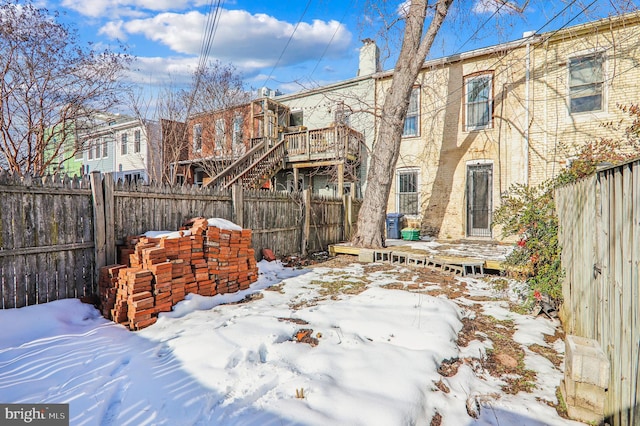 yard covered in snow with a wooden deck