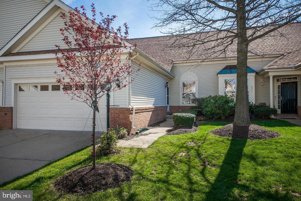 view of front of property featuring a front yard and a garage