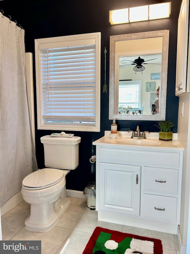 bathroom with tile patterned floors, vanity, and a healthy amount of sunlight