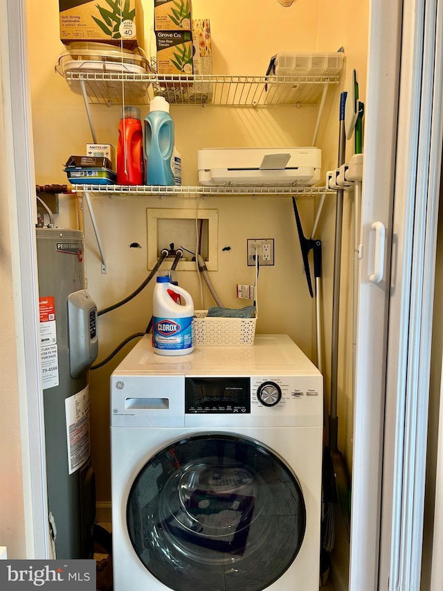 clothes washing area featuring electric water heater and washer / dryer