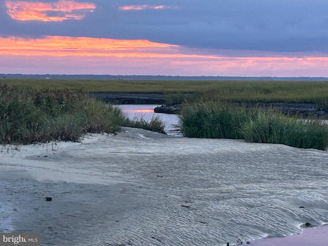 aerial view at dusk featuring a water view