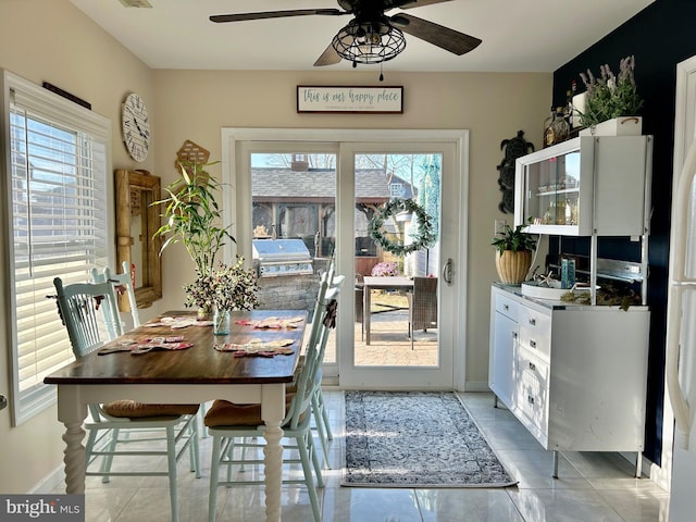 tiled dining room with a wealth of natural light and ceiling fan