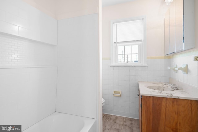 bathroom featuring toilet, vanity, tile walls, and hardwood / wood-style flooring