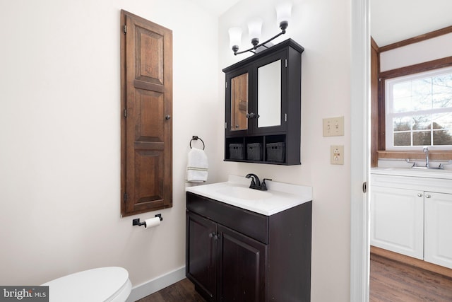 bathroom with hardwood / wood-style floors, vanity, toilet, and crown molding