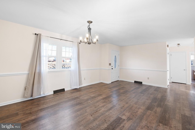 unfurnished room featuring dark wood-type flooring and a chandelier