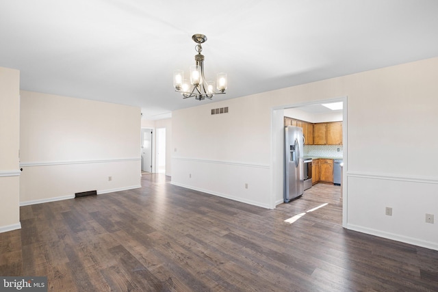 unfurnished room with a chandelier and dark hardwood / wood-style flooring