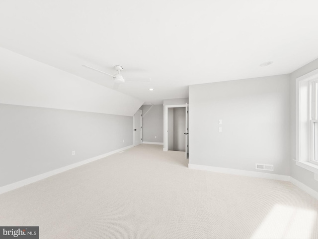 additional living space featuring light carpet, ceiling fan, and lofted ceiling