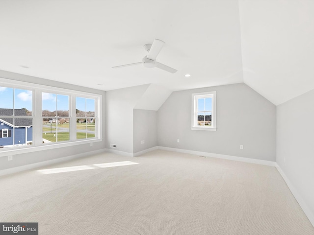 bonus room featuring light colored carpet, plenty of natural light, lofted ceiling, and ceiling fan