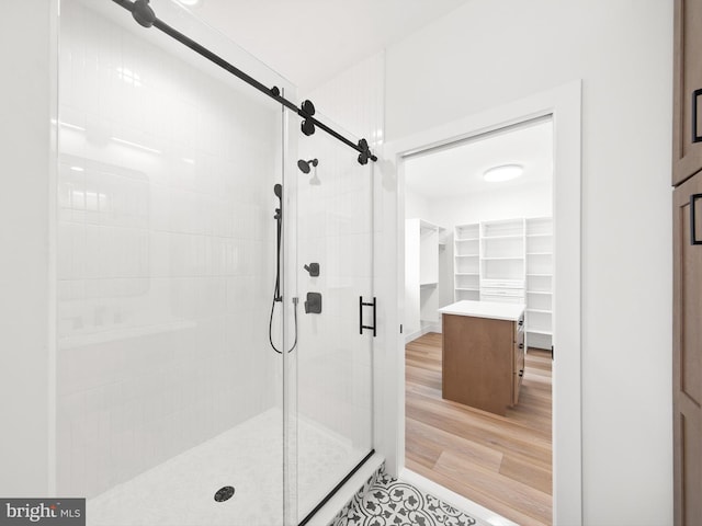 bathroom featuring a shower with door and wood-type flooring