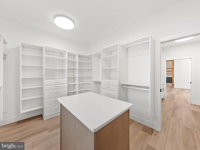 walk in closet with light hardwood / wood-style floors