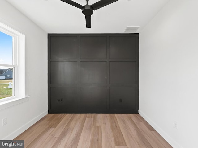 unfurnished bedroom featuring light hardwood / wood-style flooring, multiple windows, and ceiling fan