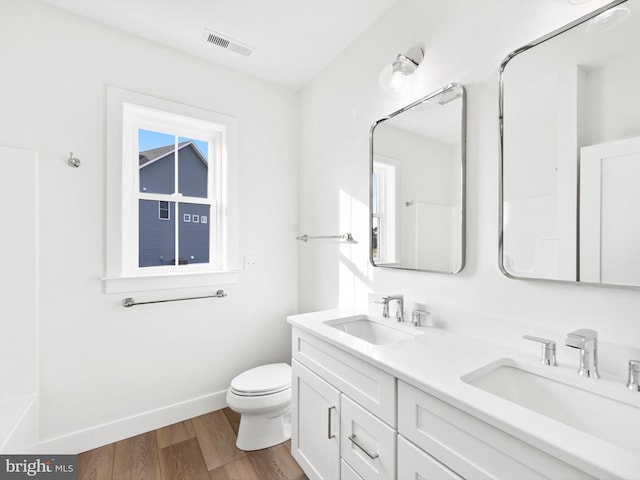 bathroom with hardwood / wood-style floors, vanity, and toilet