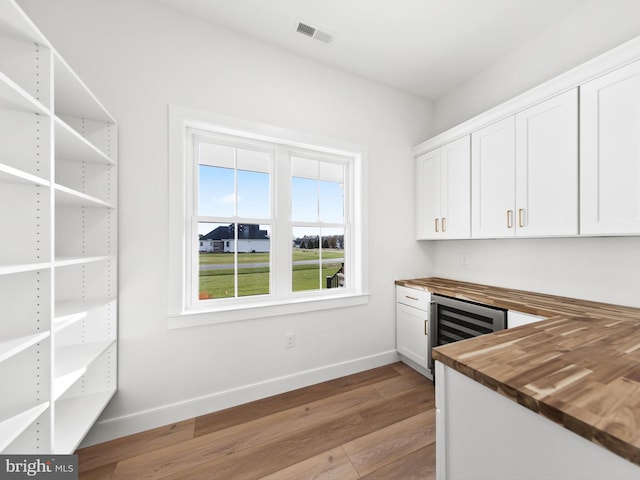 bar featuring wooden counters, white cabinetry, wine cooler, and light hardwood / wood-style flooring