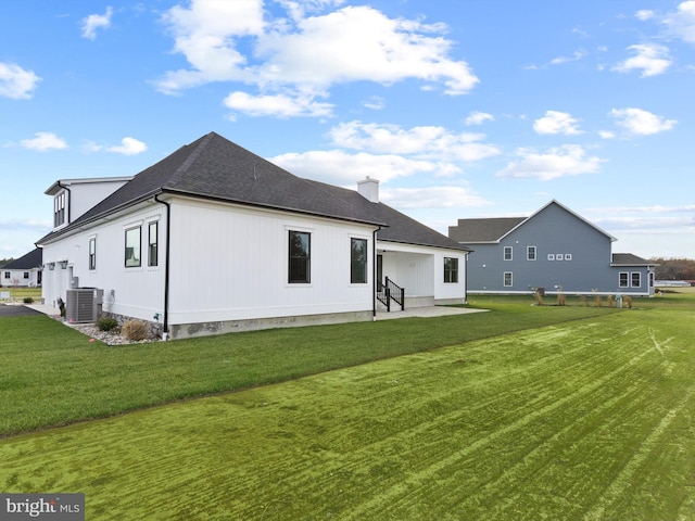 rear view of house with a yard and cooling unit