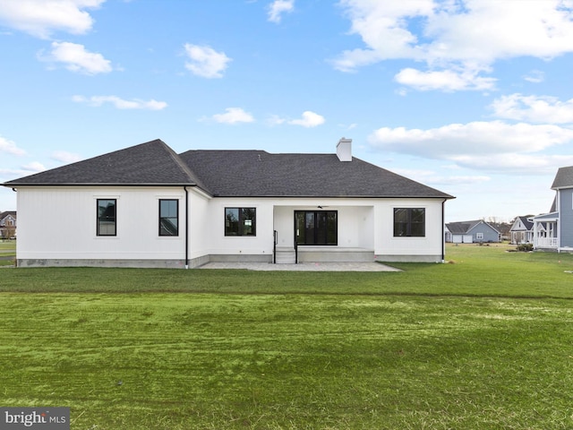 rear view of house with a patio and a lawn