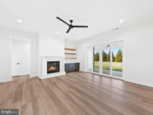 unfurnished living room featuring ceiling fan and light wood-type flooring