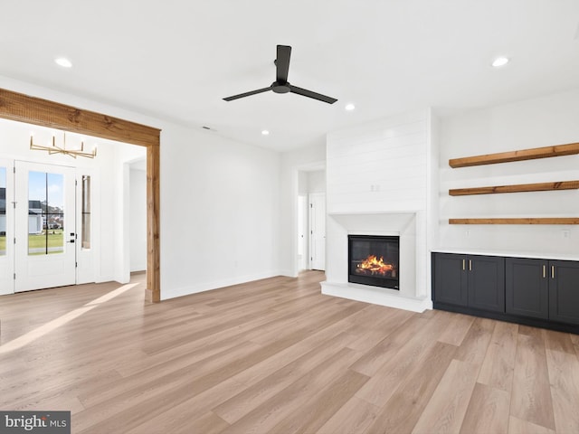 unfurnished living room with ceiling fan and light hardwood / wood-style floors