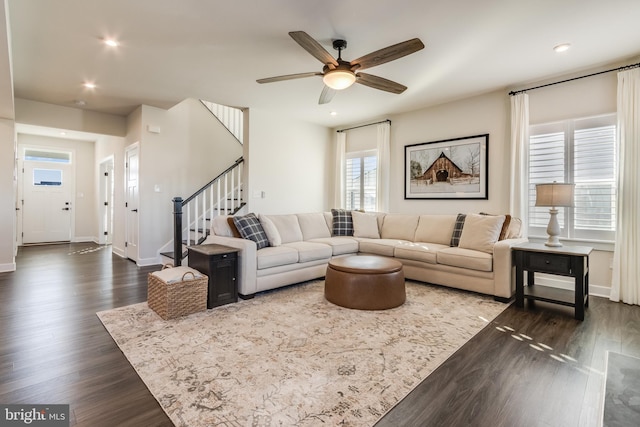 living room with ceiling fan and dark hardwood / wood-style flooring