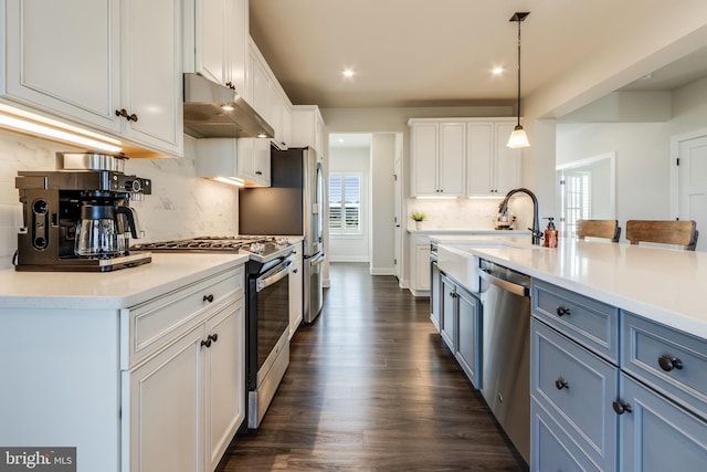 kitchen with white cabinets, a healthy amount of sunlight, stainless steel appliances, and hanging light fixtures