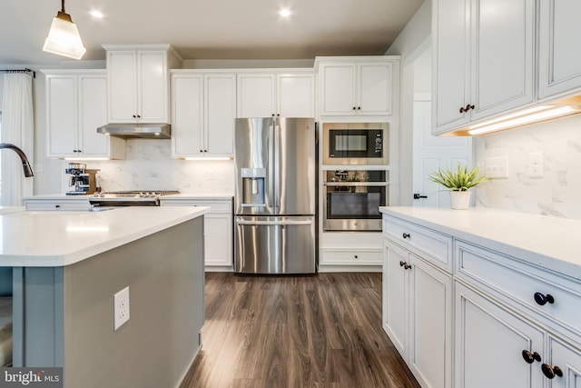 kitchen with pendant lighting, dark hardwood / wood-style flooring, white cabinetry, and appliances with stainless steel finishes