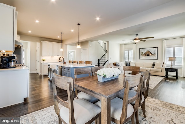 dining space with ceiling fan and dark wood-type flooring